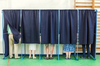 Image of voting booths via Shutterstock