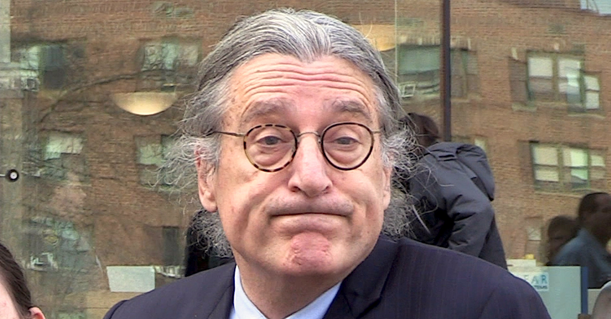 Lawyer Norm Pattis has long gray and black hair pulled into a ponytail. He is wearing glasses and raising his eyebrows as he looks directly at the camera.