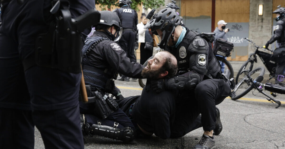 Seattle Police arrest a demonstrator who was blocking the intersection of East Pine Street and 11th Avenue after police cleared the Capitol Hill Occupied Protest (CHOP) and retook the department's East Precinct in Seattle, Washington on July 1, 2020. (Photo by Jason Redmond / AFP)