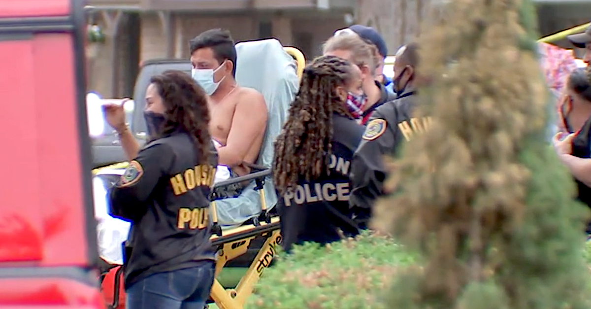 An image shows a man being wheeled out of the home in Houston where police found 90 people.