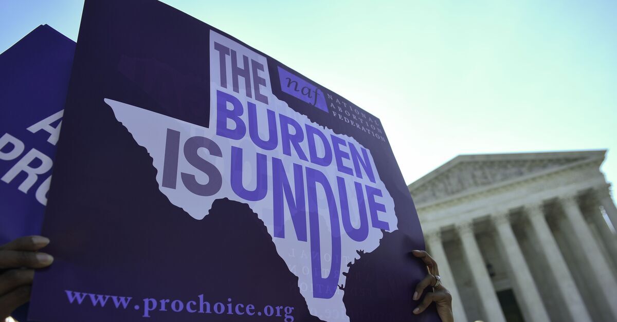 An abortion rights activist holds placards outside of the US Supreme Court before the Court struck down a Texas law placing restrictions on abortion clinics on June 27, 2016.