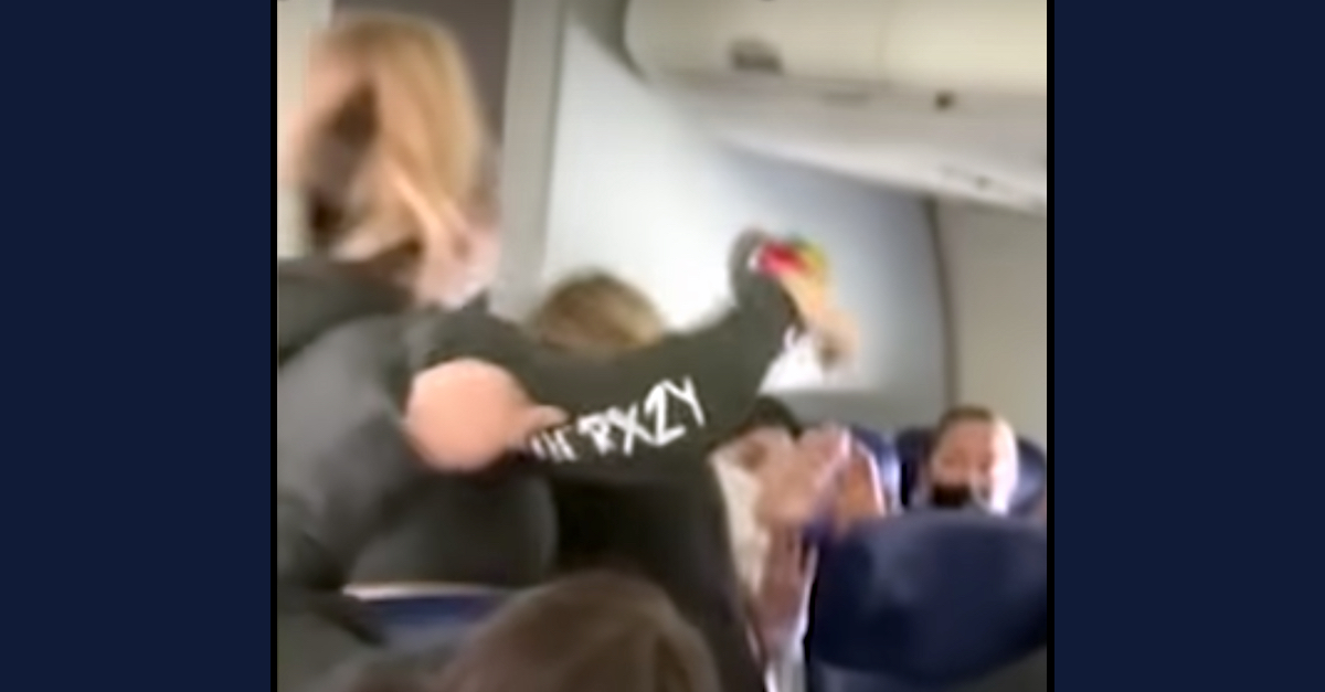 Vyvianna M. Quinonez throws a punch at a Southwest Airlines flight attendant in a video screengrab. (Image via KABC-TV/YouTube.)