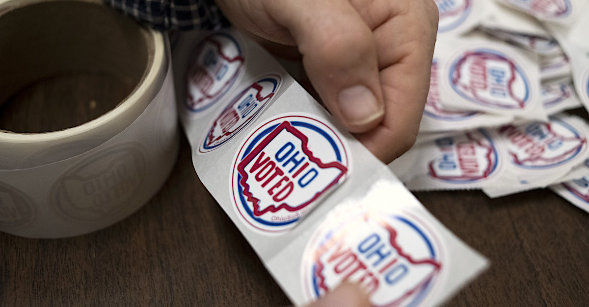 A volunteer holds a sticker which reads "Ohio Voted" at a polling place in 2020. (Photo by Ty Wright/Getty Images.)
