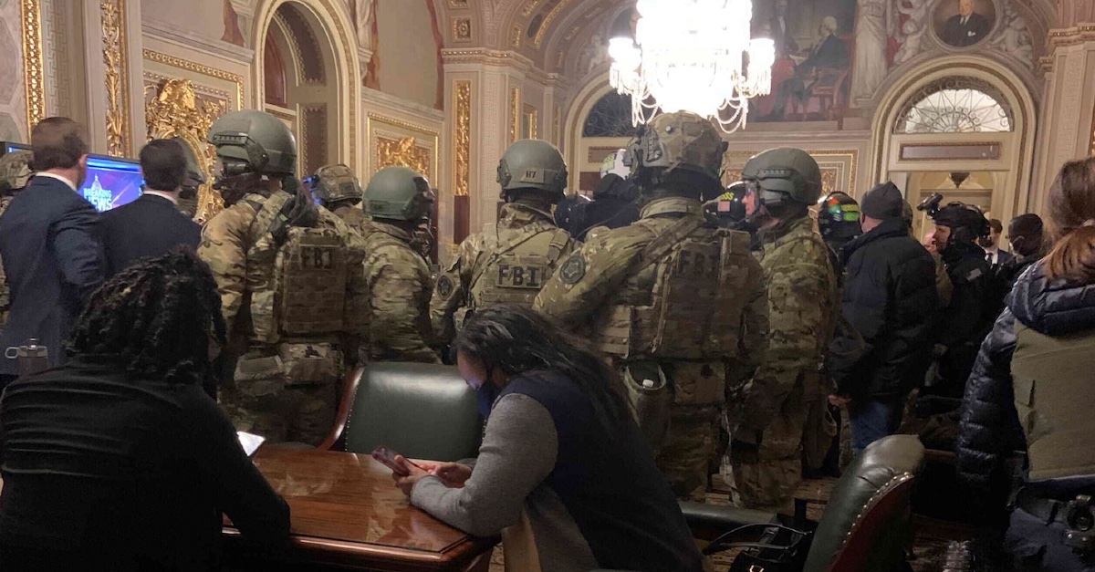 Pictured is a group of people in military gear inside the Senate antechamber as Congress prepared to resume certifying the Electoral College vote the evening of Jan. 6, 2021.