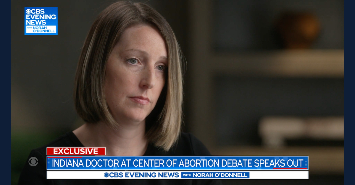 dr Caitlin Bernard, with shoulder-length, dark blonde hair that's parted on the right side, listens to a question during an interview with CBS News.