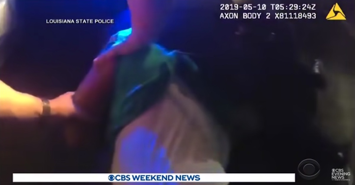 Police-worn body camera footage shows two arms restraining the body of Ronald Greene, who is wearing a green shirt over a white shirt. 
