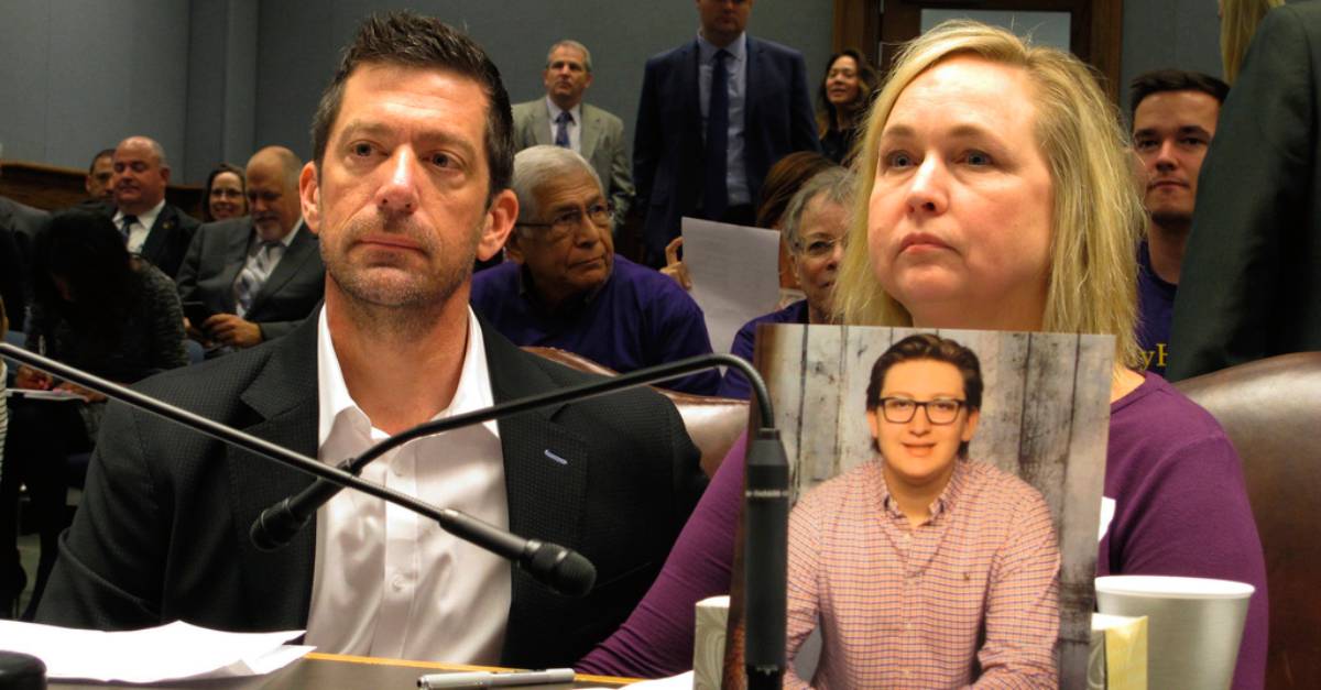 Stephen and Rae Ann Gruver sit in a House committee room behind a photo of their son, 18-year-old Maxwell Gruver, a Louisiana State University freshman who died with a blood-alcohol content six times higher than the legal limit for driving in what authorities say was a hazing incident, in Baton Rouge, La., on March 21, 2018. A jury’s decision that Gruver's family is entitled to $6.1 million for Maxwell's hazing-related alcohol death in 2017 sends a powerful message, the family’s attorney said Monday, March 13, 2023. (AP Photo/Melinda Deslatte, File)