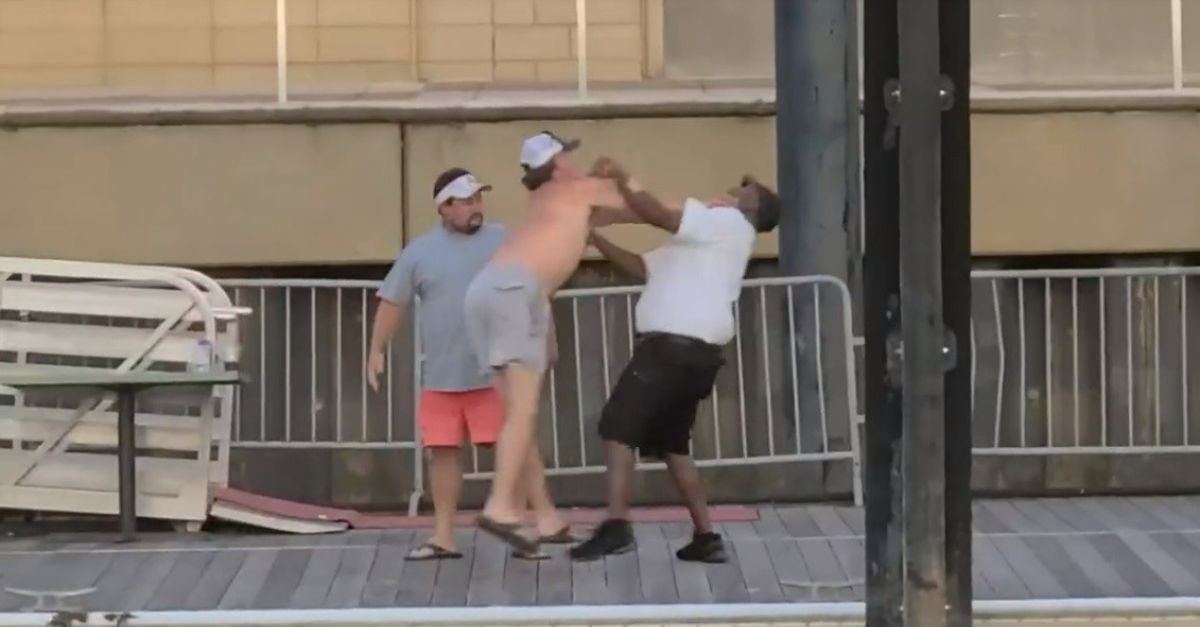 A screengrab of eyewitness footage depicts multiple men standing on a riverfront dock in Alabama in an apparent brawl.