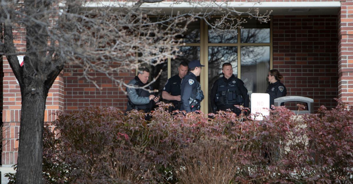 Boise police stand between the doors leading into St. Luke's Boise Medical Center and protesters outside, Tuesday, March 15, 2022, in Boise, Idaho. The hospital went on lockdown for about an hour Tuesday after far-right activist Ammon Bundy urged supporters to go the facility in protest of a child protection case involving one of his family friends. (Darin Oswald/Idaho Statesman via AP)