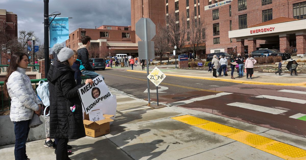 Protesters gather outside of St. Luke's Boise Medical Center in downtown Boise, Idaho, Tuesday, March 15, 2022, holding signs and shouting at Boise police who responded as the medical facility went into a security lockdown. The hospital went on lockdown for about an hour Tuesday after far-right activist Ammon Bundy urged supporters to go the facility in protest of a child protection case involving one of his family friends. (Darin Oswald/Idaho Statesman via AP)