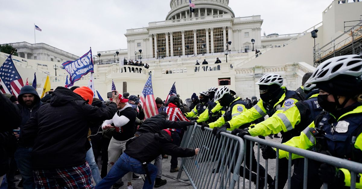 FILE - In this Jan. 6, 2021, file photo, Trump supporters try to break through a police barrier at the Capitol in Washington. For America
