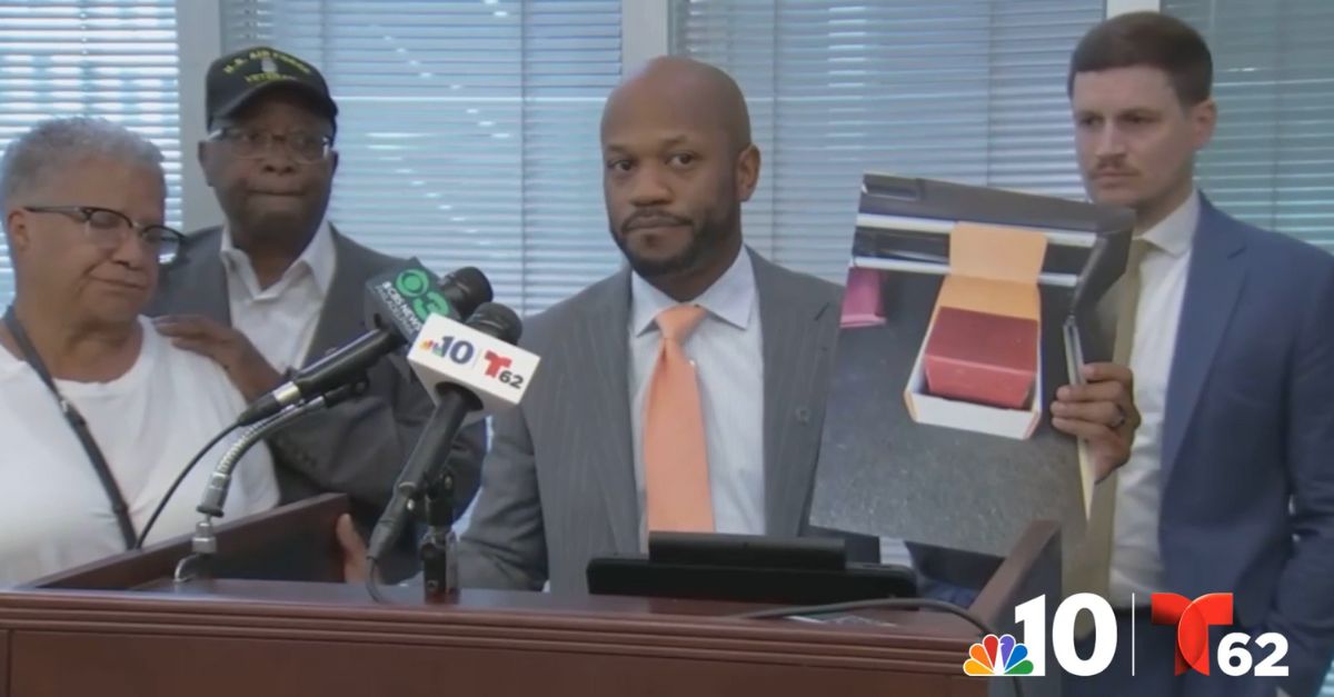 Attorney L. Chris Stewart holds up a photo of the box that contained human remains belonging to the son of Abbey and Lawrence Butler (WCAU).