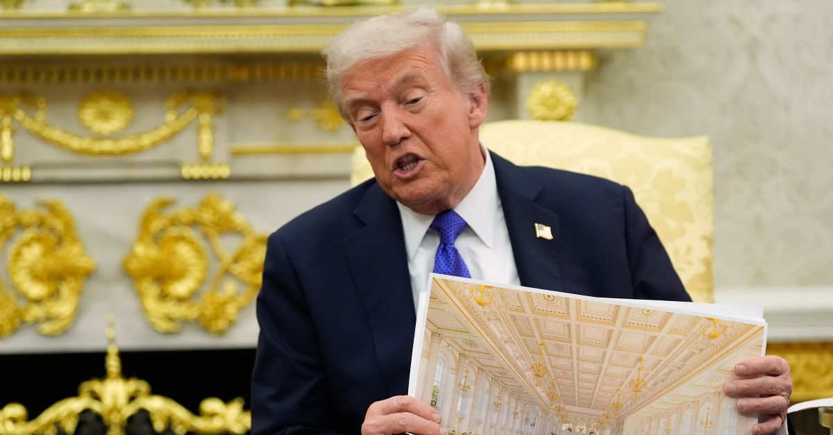Donald Trump holds a rendering of a ballroom in the White House.